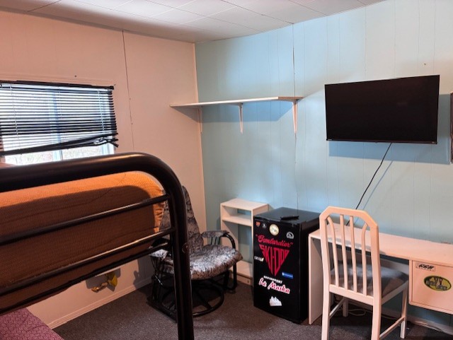 Chambre dortoir du Relais Onatchiway : lits superposés, bureau, télévision, fauteil et refrigérateur