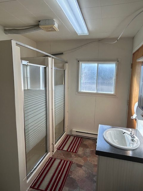 Salle de bain commune du Relais Onatchiway : douches et lavabo