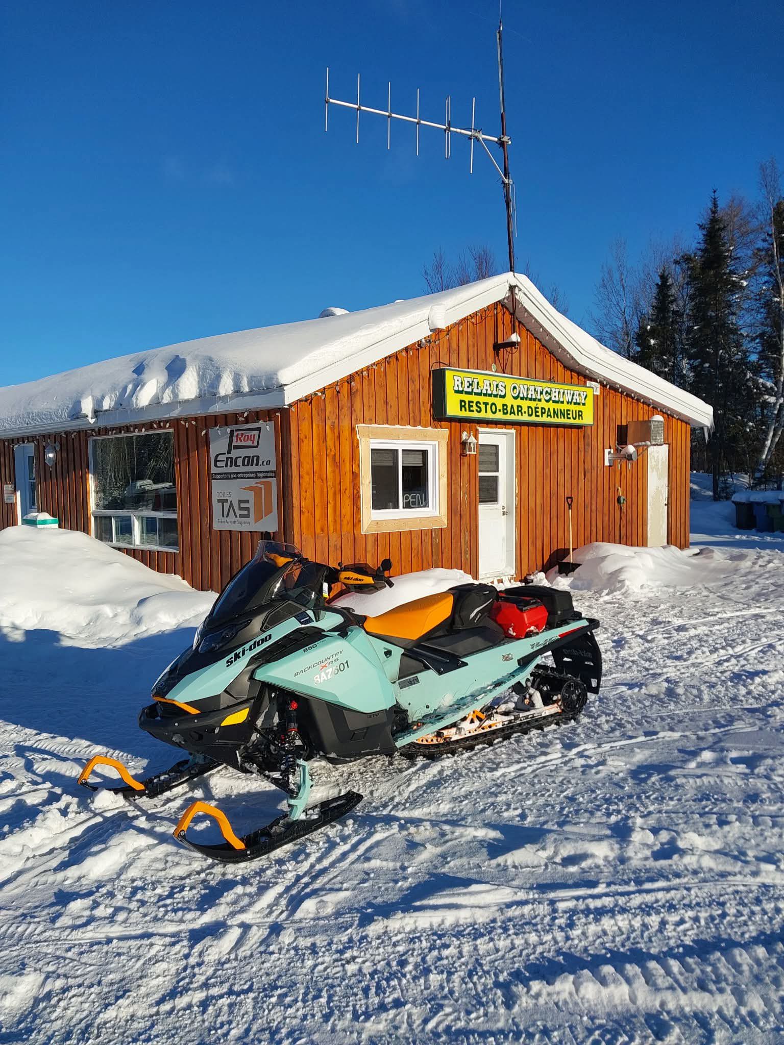 Motoneige devant le restaurant du Relais Onatchiway en hiver