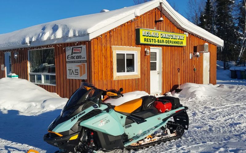 Motoneige devant le restaurant du Relais Onatchiway en hiver